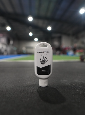 Close up of a 50ml liquid chalk with a gym in the back ground